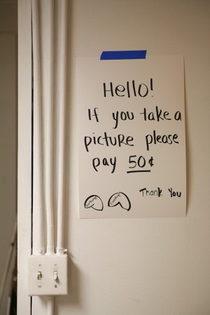 The sign says Hello If you take a picture please pay 50 cents, so I owe her or them 50 cents, right? (from In the Make)